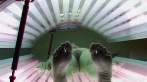 Tanned brunette flicks the bean in a tanning bed